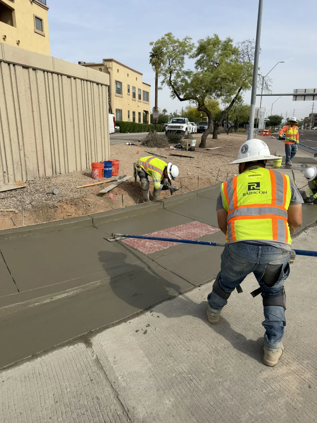 Raincon worker finishing concrete during the day